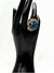 Earthy, reminiscent, bold design, oceanic blue hue center stone surrounded by textured, gold-toned settingone size fits allstatement ringvacation ring bold ringunique designgold jewelry gold ring earthy ring