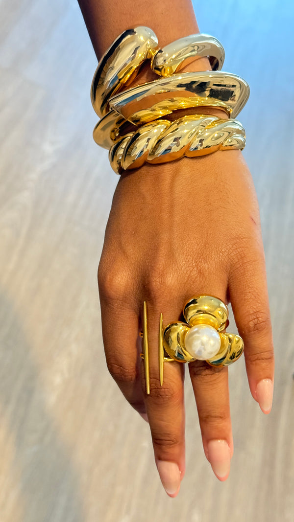Golden embrace cuff braceletChunky gold cuff jewelryInterlocking gold-tone braceletSculptural gold bangleElegant statement braceletMinimalist gold arm accessoryModern gold cuff jewelryBold and chic wrist cuffPolished gold bracelet for womenTimeless gold statement jewelry