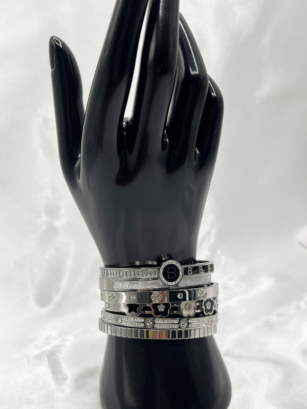 Silver bangle stackFloral motif banglesCrystal embellished braceletsElegant silver jewelryWomen's bangle setFashionable silver-toned banglesSophisticated bracelet stackStylish wrist accessoriesChic silver bangles