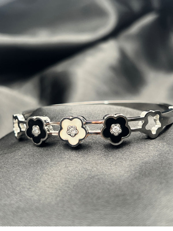 Silver bangle stackFloral motif banglesCrystal embellished braceletsElegant silver jewelryWomen's bangle setFashionable silver-toned banglesSophisticated bracelet stackStylish wrist accessoriesChic silver bangles