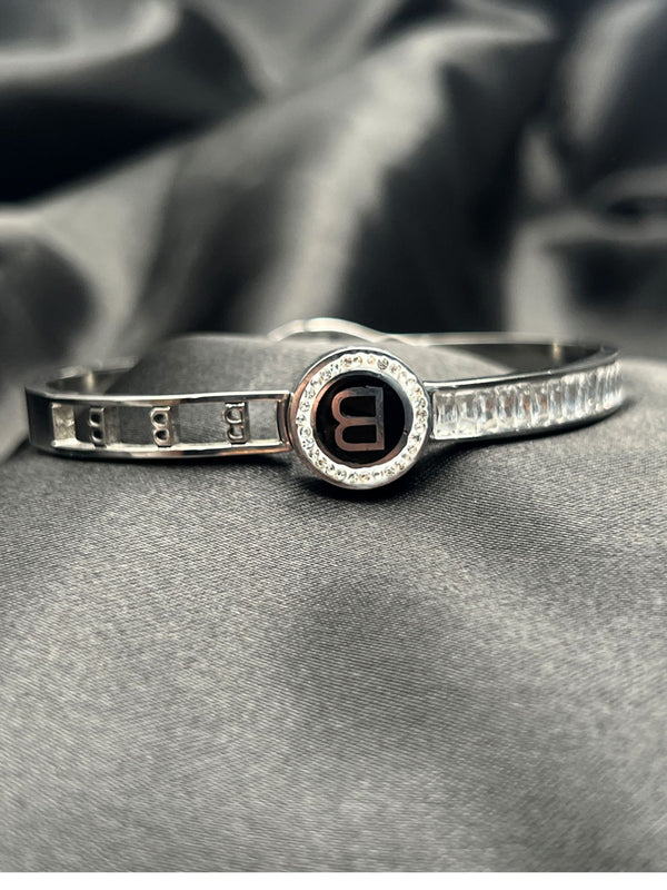 Silver bangle stackFloral motif banglesCrystal embellished braceletsElegant silver jewelryWomen's bangle setFashionable silver-toned banglesSophisticated bracelet stackStylish wrist accessoriesChic silver bangles