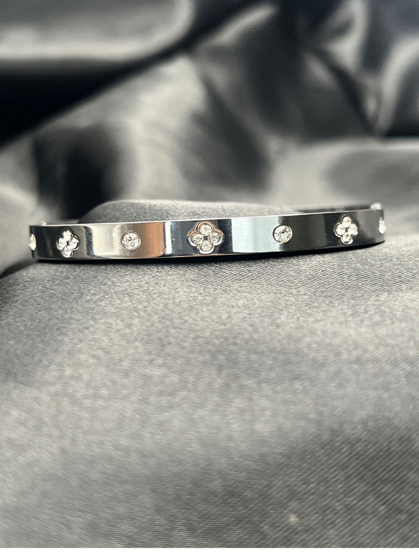 Silver bangle stackFloral motif banglesCrystal embellished braceletsElegant silver jewelryWomen's bangle setFashionable silver-toned banglesSophisticated bracelet stackStylish wrist accessoriesChic silver bangles