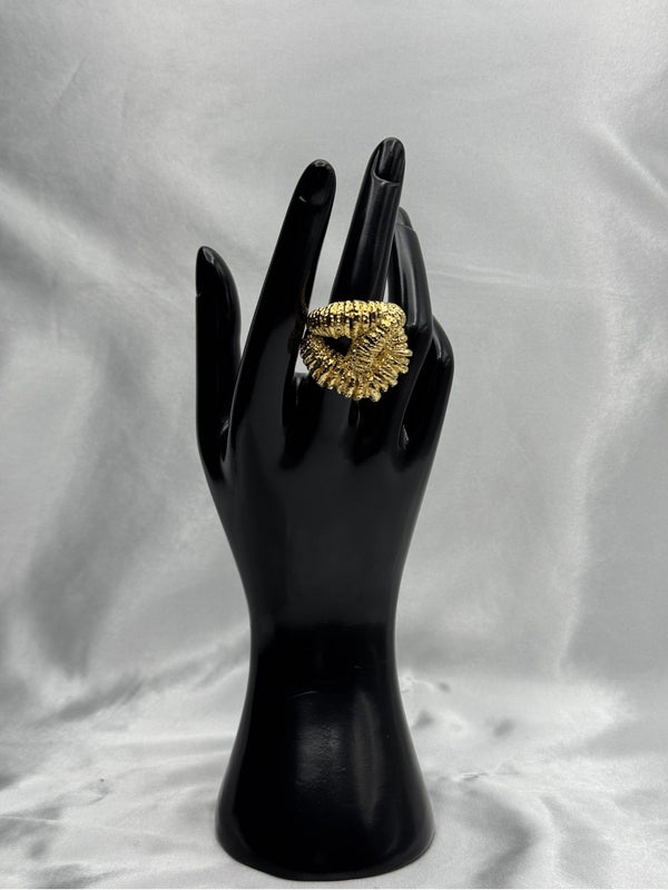 textured gold twist ring. Its intricate design features a twisted, rope-like structure with detailed texture, giving it a unique and eye-catching look. This ring is perfect for those who love chunky, statement jewelry and want to add a touch of luxury to their collection. Ideal for elevating any outfit, whether casual or formal.Gold twist ringTextured gold ringChunky statement ringUnique fashion jewelryBold gold ringLuxury fashion accessoriesTwisted gold ring designStatement ring