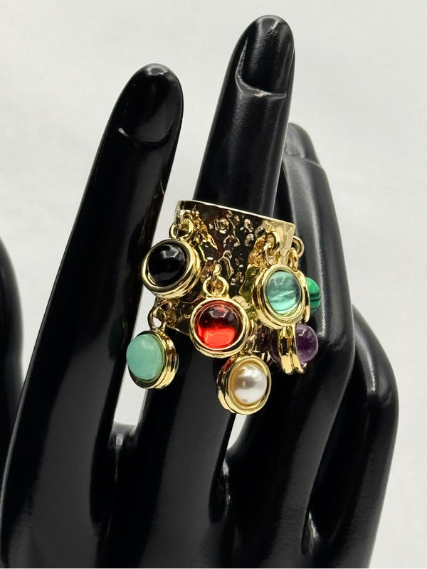 luxurious gold-tone band adorned with multiple vibrant, natural-colored stone charms. Each charm showcases a different gem, including shades of green, red, purple, black, and white with aunique dangling design. statement ringgold-tone ring with charmsmulticolor stone ringadjustable gemstone ringboho chic jewelrybold fashion ringeclectic ring designnatural stone jewelryunique tassel ringtrendy women's accessories