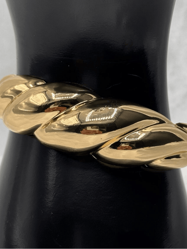 Gold ripple braceletBold statement braceletModern gold bangleLuxurious gold-tone jewelryRipple design braceletChunky gold bracelet for womenElegant wrist accessoriesContemporary statement jewelryStylish gold arm jewelryVersatile gold bangle bracelet