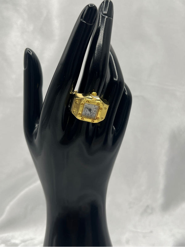 Gold-Tone Square Watch Ring with White Dial. One sizesquare face with black numerals on a white dial, this piece offers a modern twist on a classic designgold-tone watch ringsquare face ring watchstylish gold watch ring for womenelegant quartz watch ringfashion-forward timepiece jewelrygold statement ring with white dialwomen’s fashion accessory watchfunctional jewelry with gold designtrendy watch ring for womenluxury gold-tone ring watch