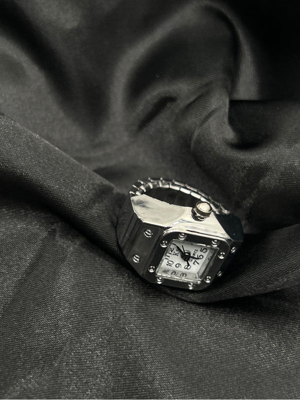 Silver-Tone Watch Ring with White Face. Unique, silver-tone, watch ring, featuring a chic square face with clear, easy-to-read black numerals. Combining the functionality of a watch with the elegance of a ring. Ffashion with a practical twist. silver-tone watch ringsquare face watch ringstylish watch ring for womenrhinestone watch ringelegant watch ring with white dialfunctional jewelryquartz watch ringstatement timepiece jewelrywomen’s fashion ring watchunique silver-tone ring. One-size.