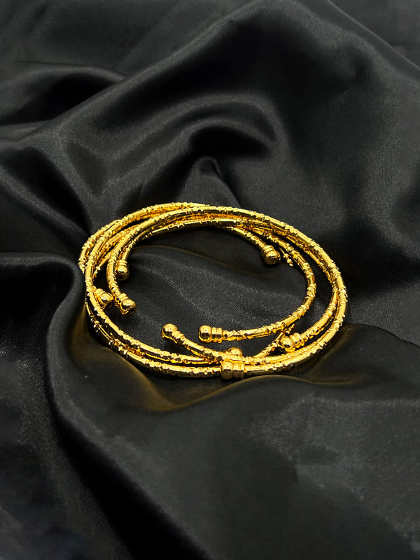 layered gold bangles, textured gold bracelets, elegant bangle set, stylish stacked bangles, women’s gold wrist jewelry, fashion bangles set, versatile gold