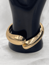 Golden embrace cuff braceletChunky gold cuff jewelryInterlocking gold-tone braceletSculptural gold bangleElegant statement braceletMinimalist gold arm accessoryModern gold cuff jewelryBold and chic wrist cuffPolished gold bracelet for womenTimeless gold statement jewelry